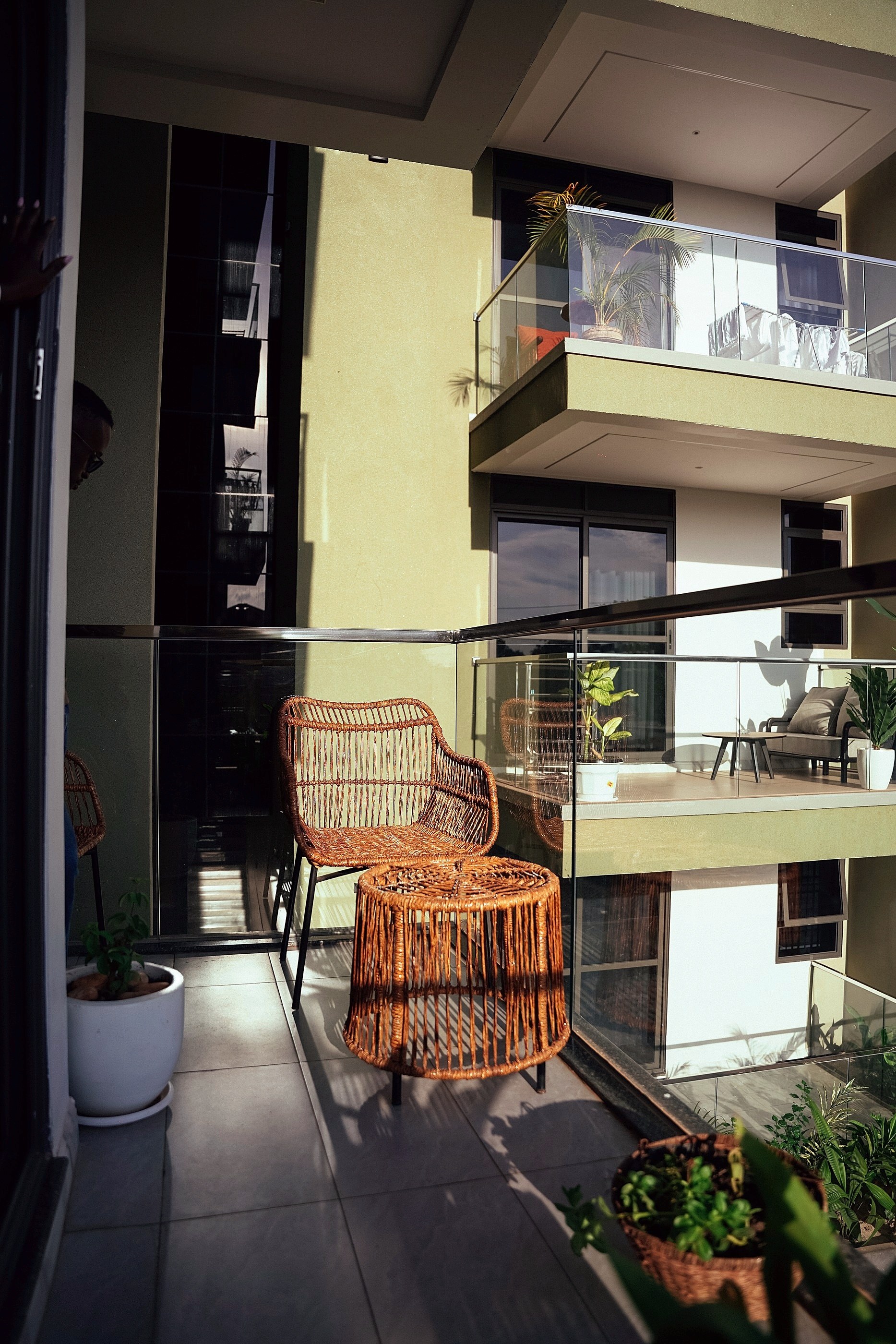 The balcony in shade with the rattan chairs and potted plants