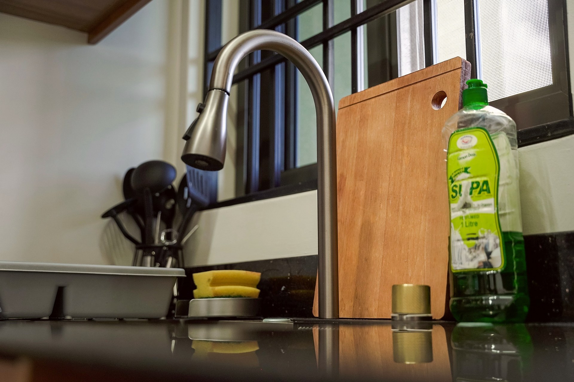 A pull down kitchen tap in front of the window