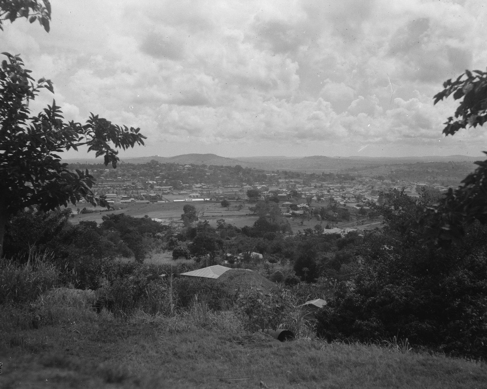 A black and white view over a low, tree filled Kampala town towards distant hills, taken from Namirembe in 1936