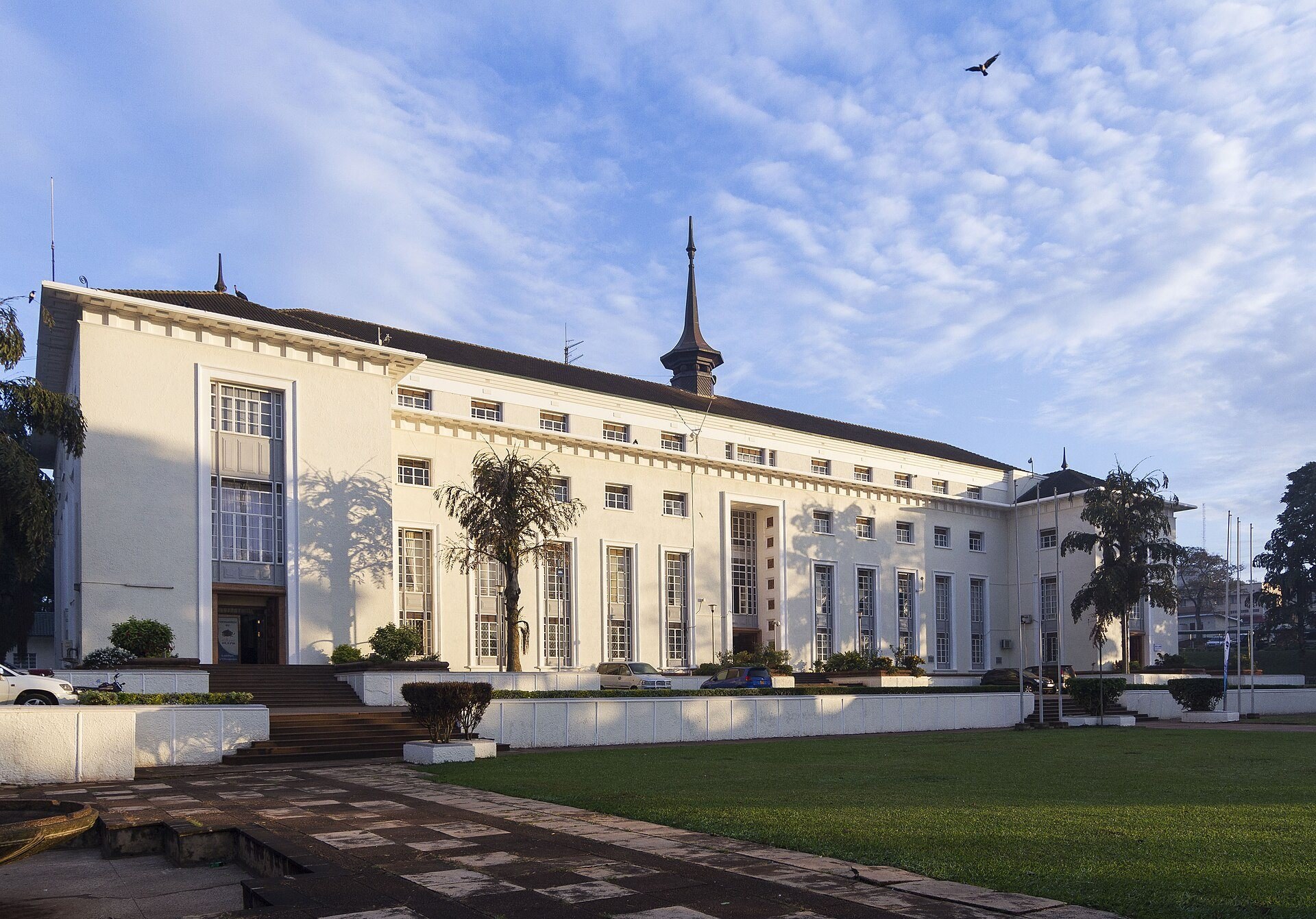 The long white facade of the Bulange with its central spire, under a blue sky