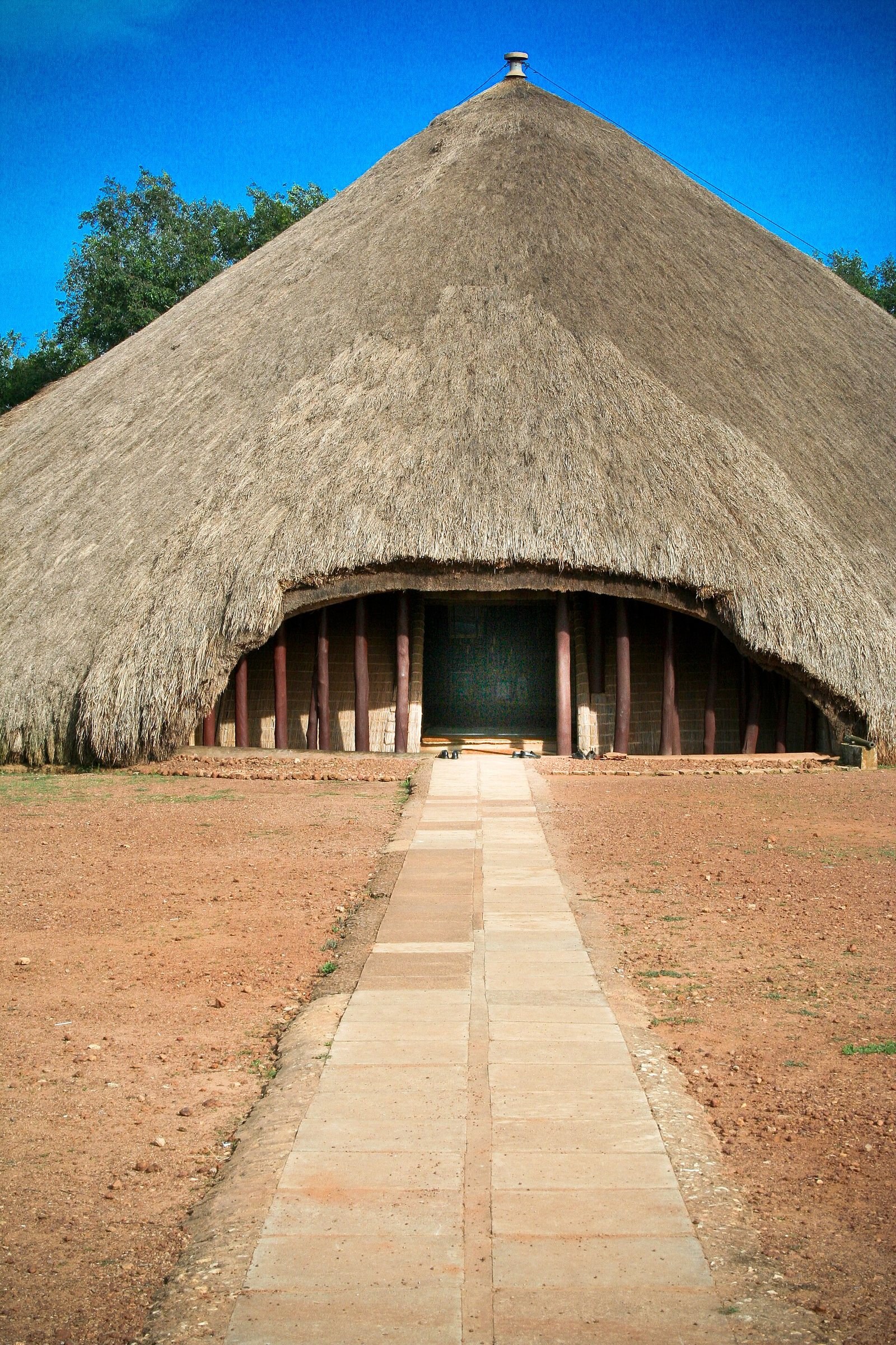 The great thatched dome of Muzibu Azaala Mpanga at Kasubi, with a stone path leading to its entrance